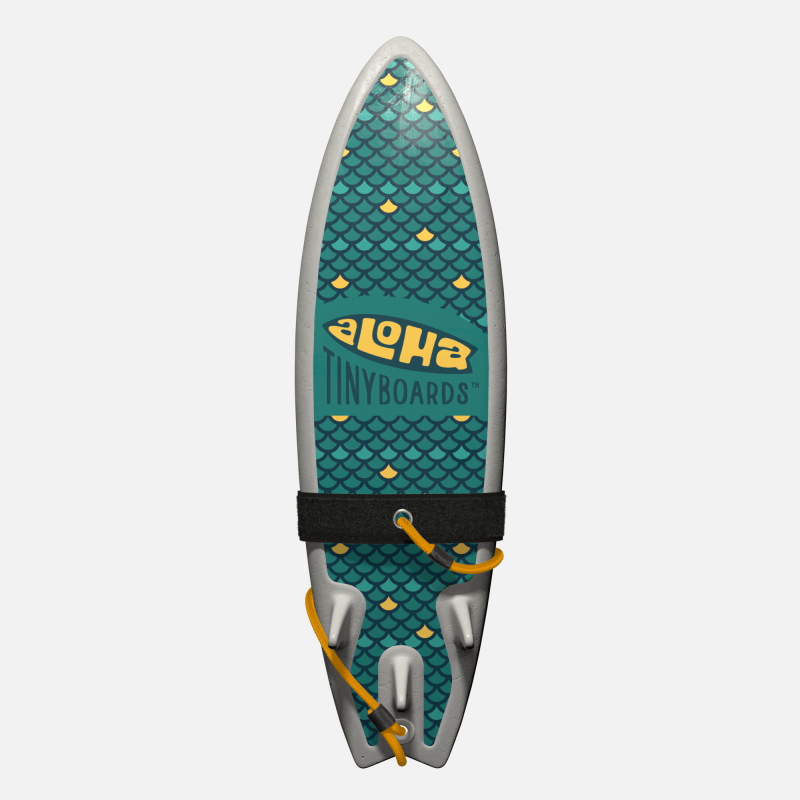 Animated GIF of Aloha Tinyboards foam finger surfboard rotating 360° showing the Fish Scales repeating teal-and-yellow scale motif.