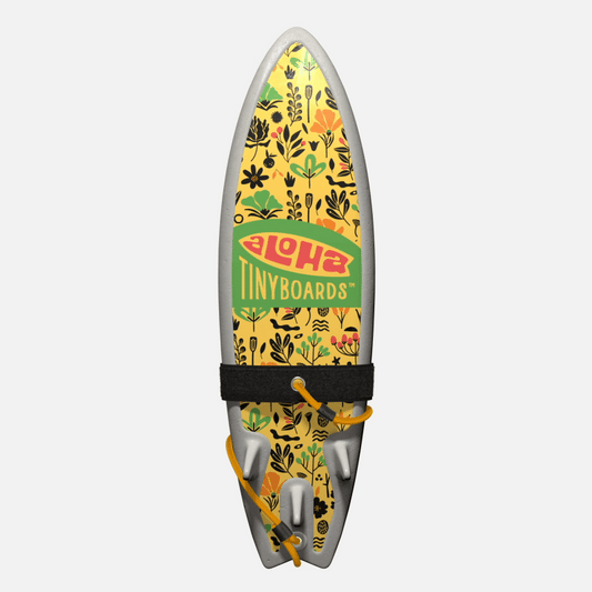Animated GIF of Aloha Tinyboards foam finger surfboard rotating 360° showing Floral Minimal black-and-green botanical silhouettes on yellow.