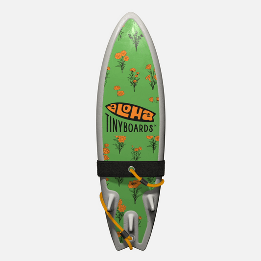 Animated GIF of Aloha Tinyboards foam finger surfboard rotating 360° showing Marigolds orange floral sprigs on green field.