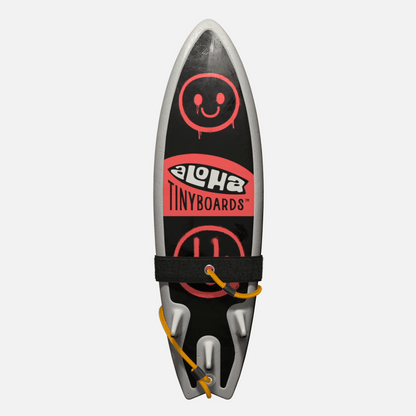 Animated GIF of Aloha Tinyboards foam finger surfboard rotating 360° showing Spraypaint coral spray-smiley motifs on black.
